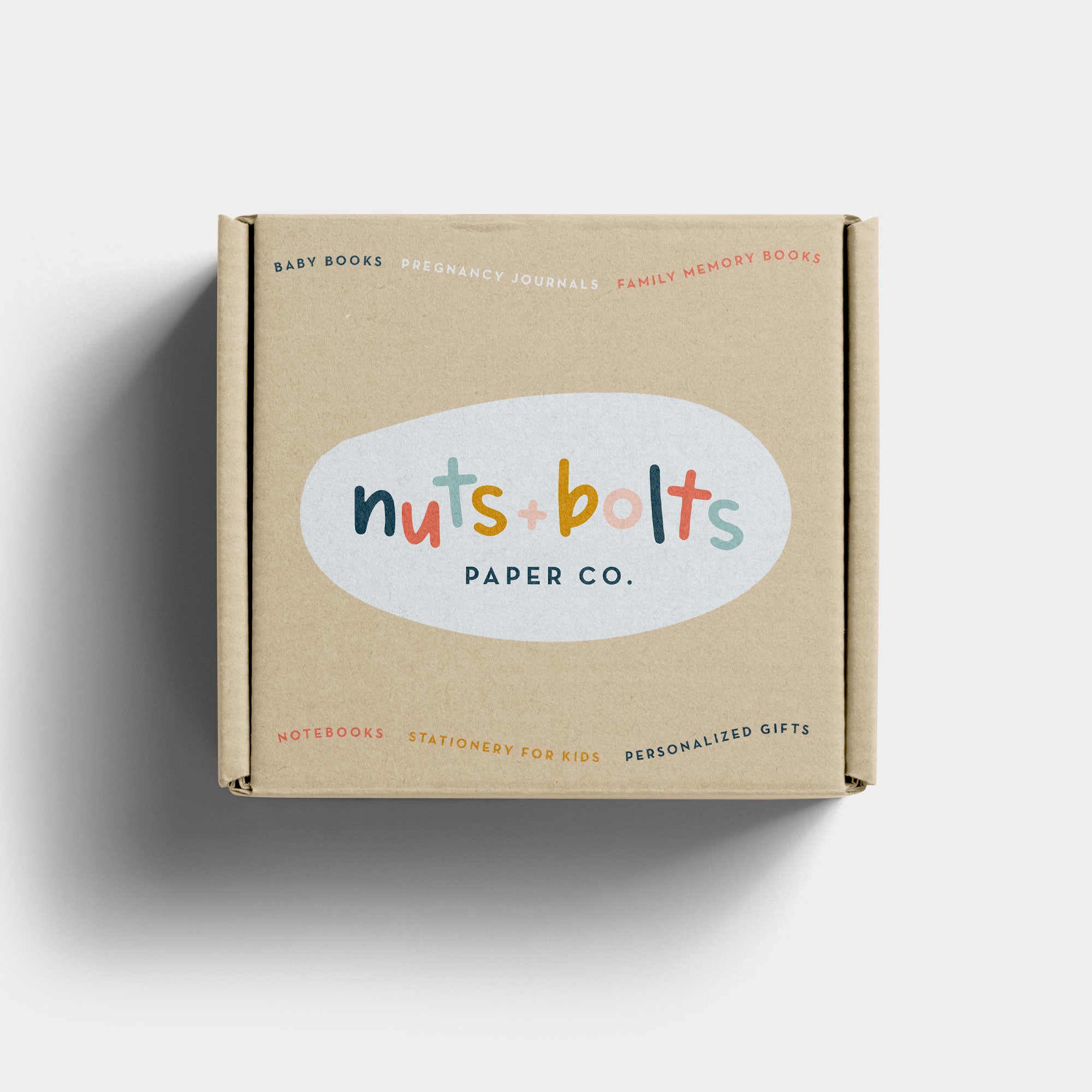 Cardboard box with 'nuts & bolts paper co.' logo on a white background designed by O Hey Amy